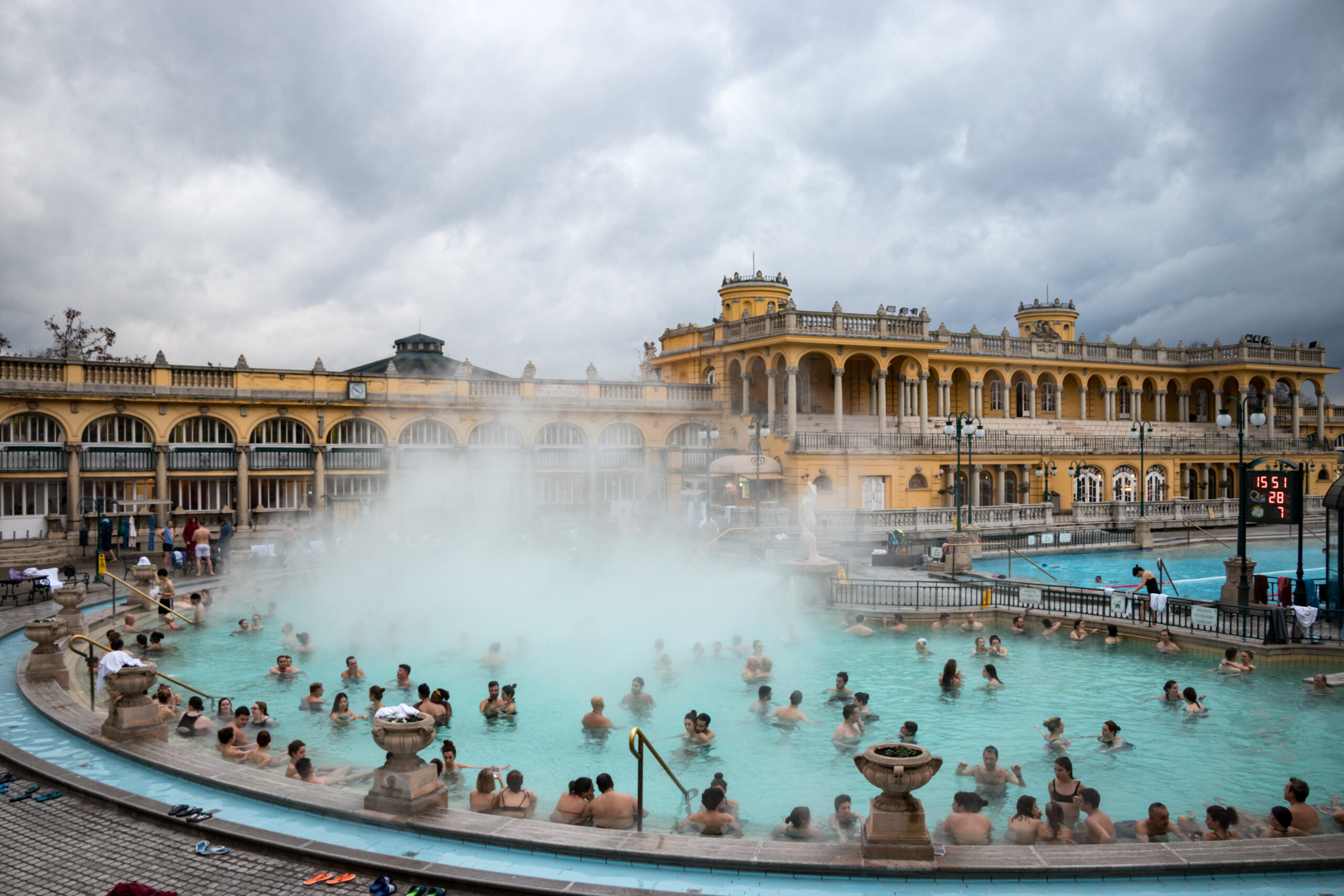 Thermal baths with bathers and classic building in backdrop